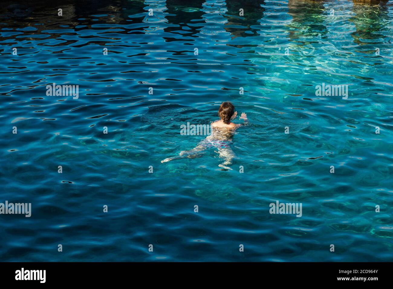 Spain, Canary Islands, La Palma, young woman swimming in a natural pool of sea water Stock Photo