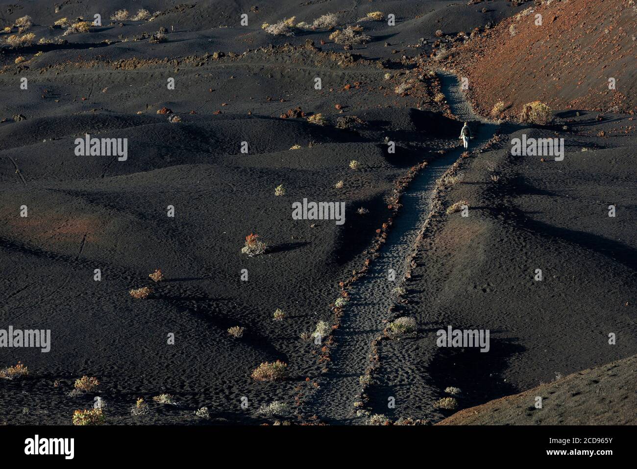 Spain, Canary Islands, La Palma, hiker on a trail in a desert and volcanic environment at sunrise Stock Photo