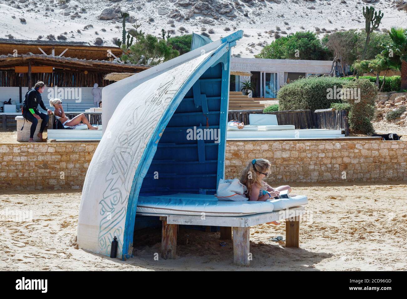 Marocco, Oued Ed-Dahab, Dakhla, Ocean Vagabond Resort, guests of a luxury eco-lodge sitting on a beach lounge in the sun Stock Photo