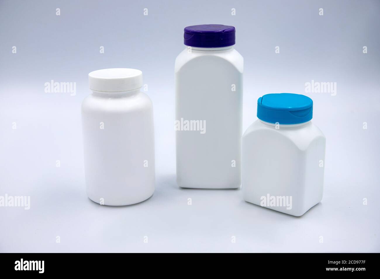 White plastic bottles for pills or vitamins on white background. Round and square pharmacologic container mockup. Pill or drug jar blank package desig Stock Photo