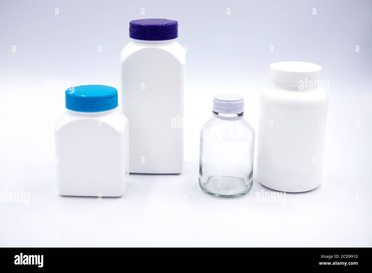 White plastic bottles for pills or food supplement studio photo on white background. Set of pharmacologic container mockup. Pill or drug jar blank pac Stock Photo