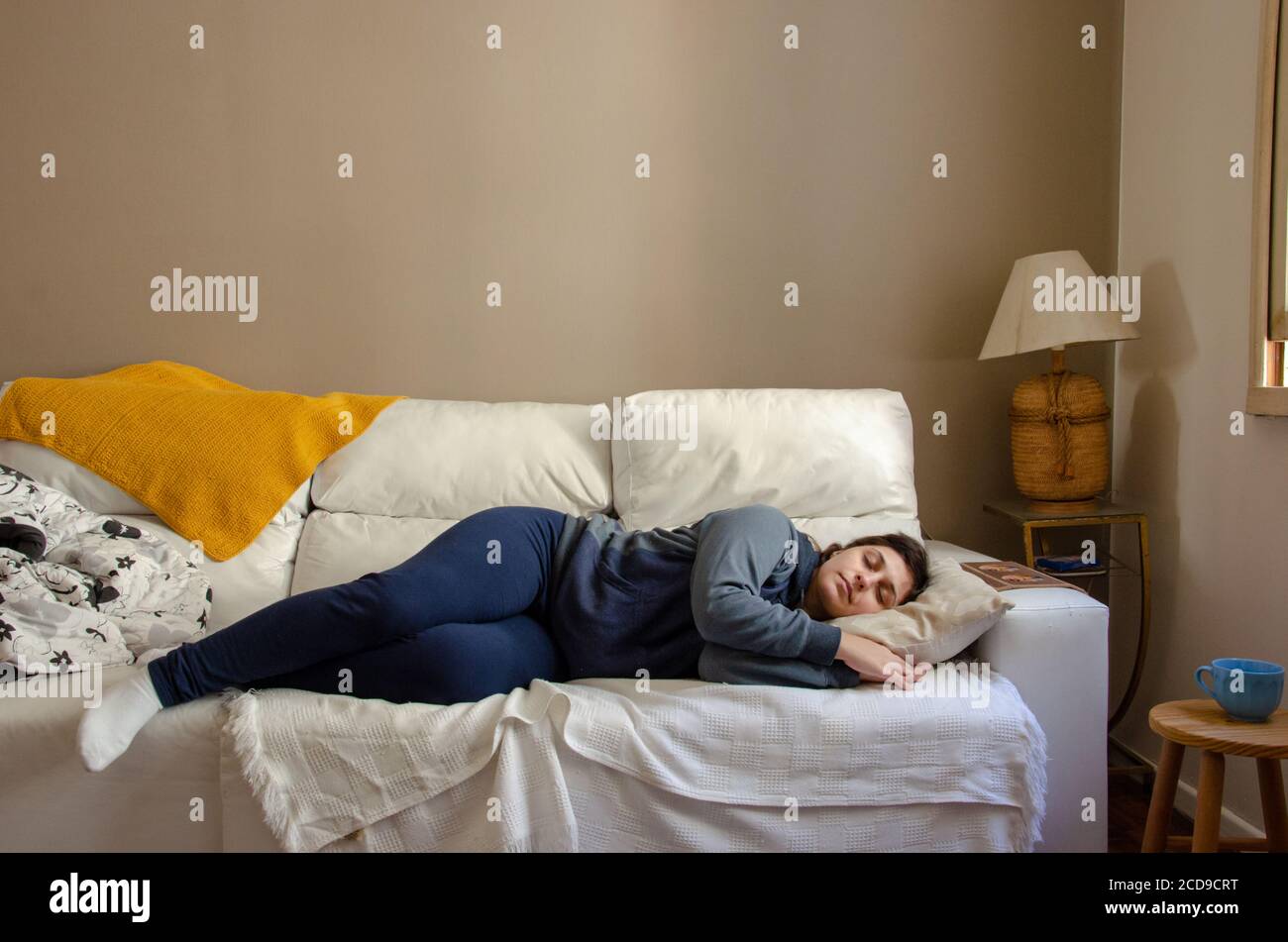 young woman sleeping on a white couch using comfort clothes Stock Photo