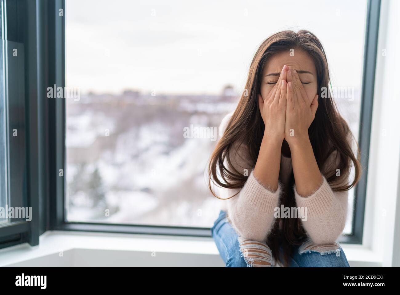 Anxiety winter depression woman having a panic attack and a hard time breathing. Home alone girl crying stressed depressed Stock Photo