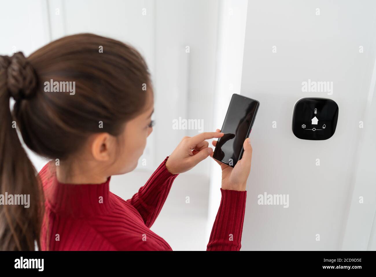 Smart home automation woman using phone app regulating indoor temperature regulation smart house