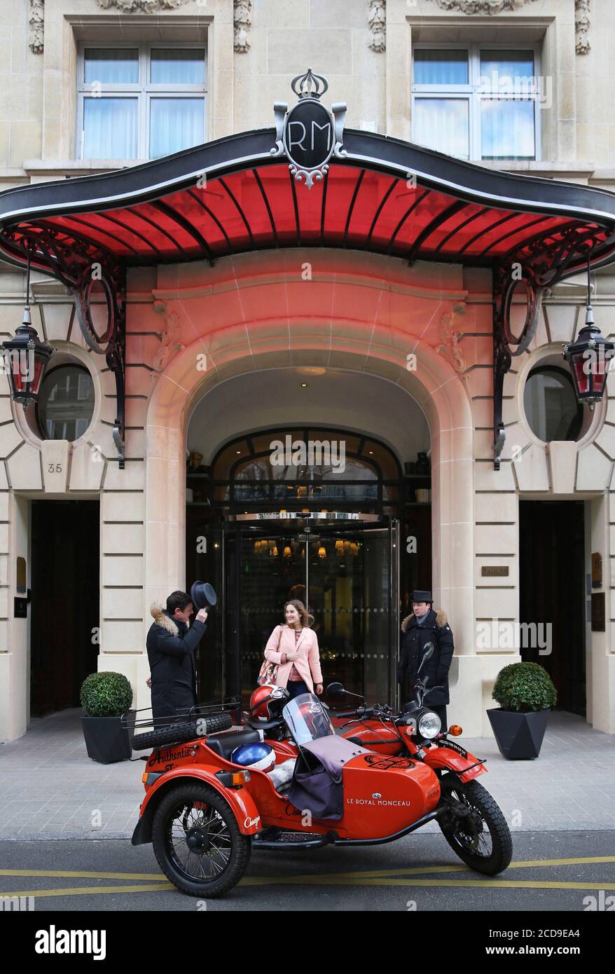 France, Paris, Royal Monceau hotel, woman riding in a retro side car in front of the hotel facade guarded by two valet Stock Photo