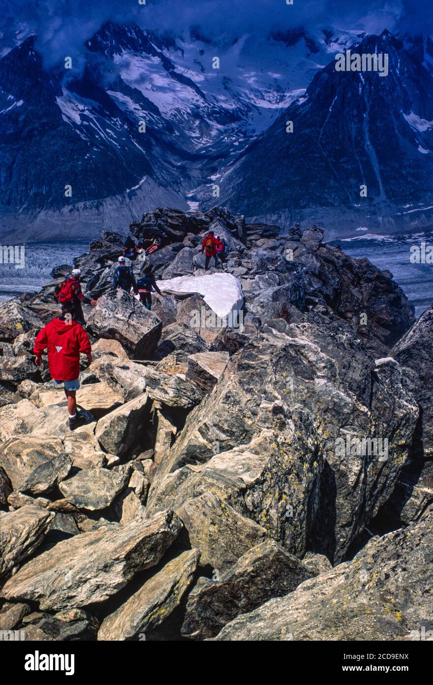 Visitors scramble over boulders at the summit of the Eggishorn in Switzerland to view the Aletschglacier, source of the Rhone, archive image from 1990s Stock Photo