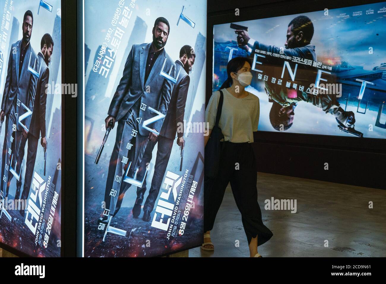 Seoul, South Korea. 26th Aug, 2020. A woman wearing protective mask walks by billboards of the movie 'TENET'.Movie 'TENET' directed by Christopher Nolan is released on 26 August in South Korea for the first time in the world. Credit: SOPA Images Limited/Alamy Live News Stock Photo