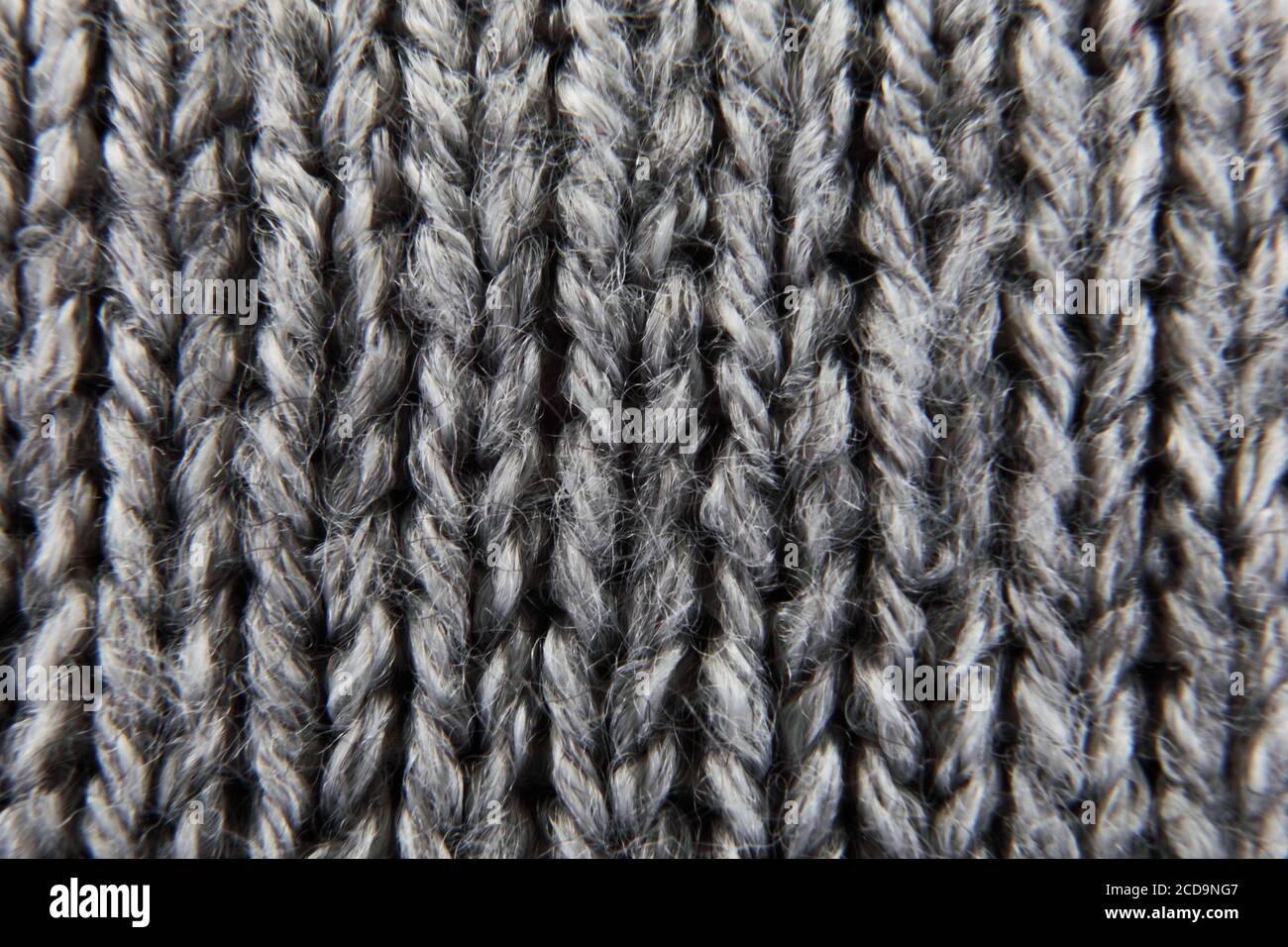 Grey ribbed knitted wool background texture macro with selective focus Stock Photo