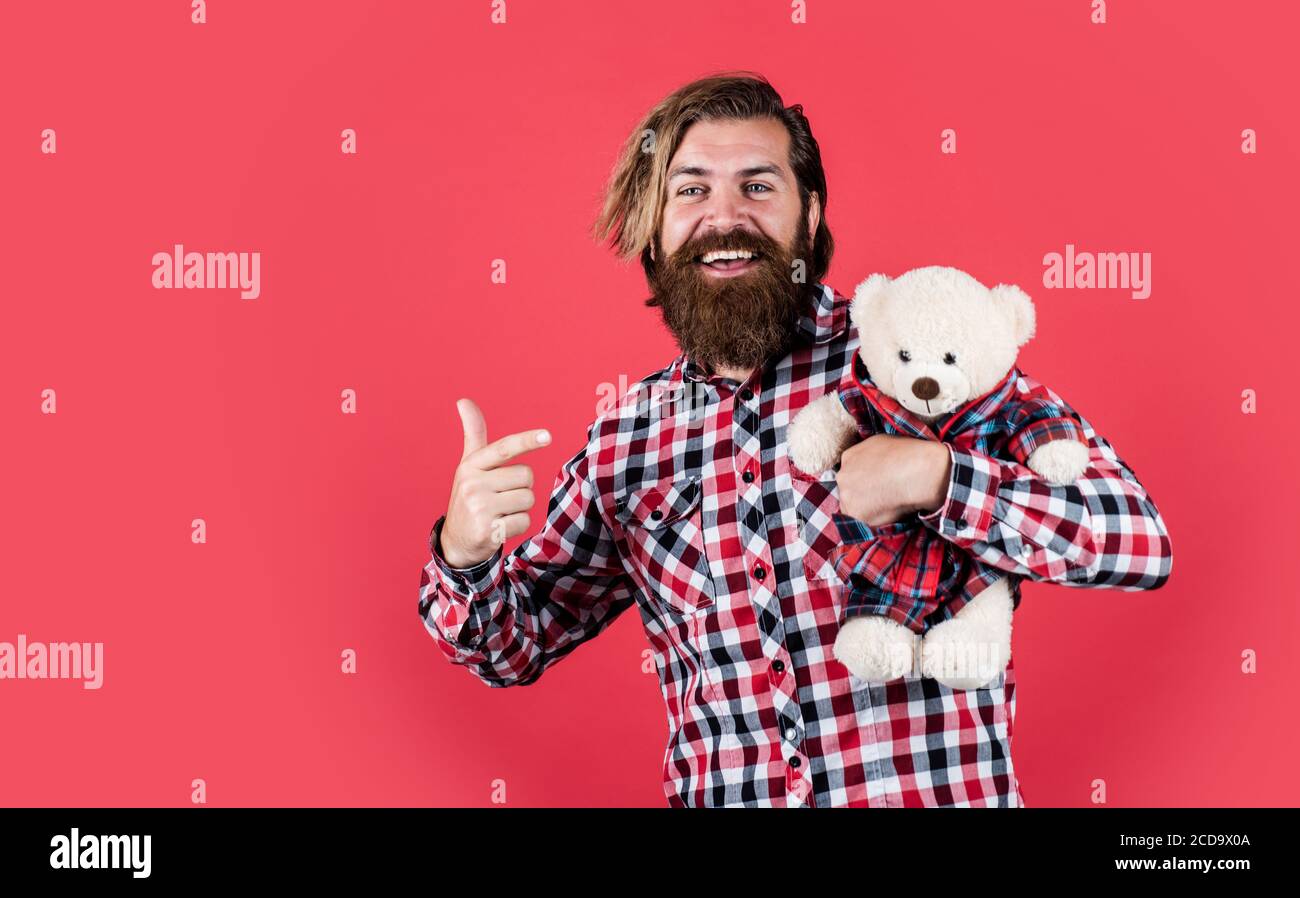 look at this. Guy with happy face plays with soft toy. Childish mood concept. guy enjoy valentines day. best present ever. Valentines day gift for beloved. Holiday celebration concept. Stock Photo