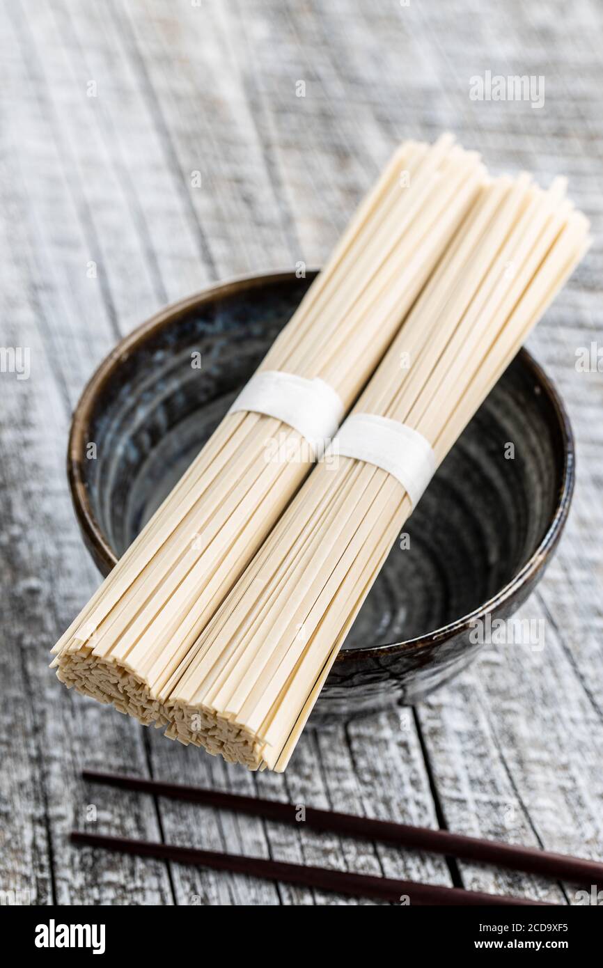 Uncooked udon noodles. Traditional Japanese noodles on bowl Stock Photo