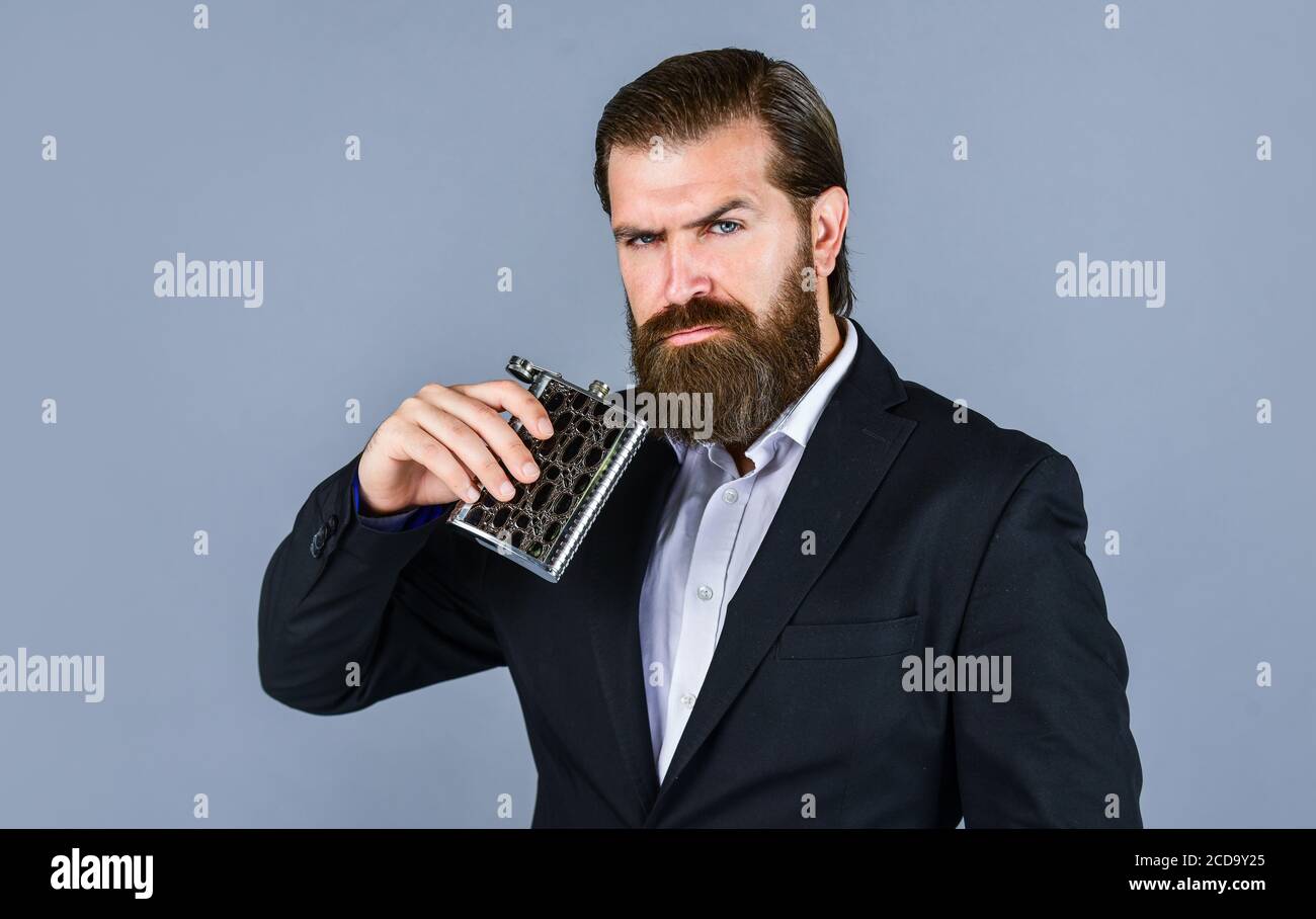 drink for refreshing. vintage gentleman gift shop. Brutal businessman drinking alcohol. Man with his booze flask. man drinks strong alcohol from iron flask while relaxing. Hip flask for whiskey. Stock Photo