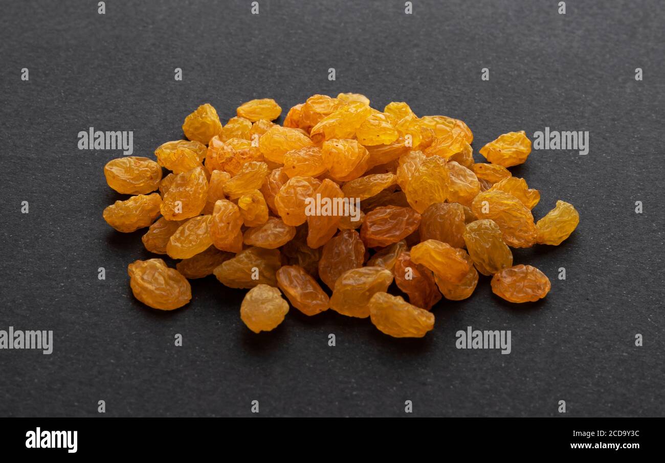 Golden raisins on black background Stock Photo