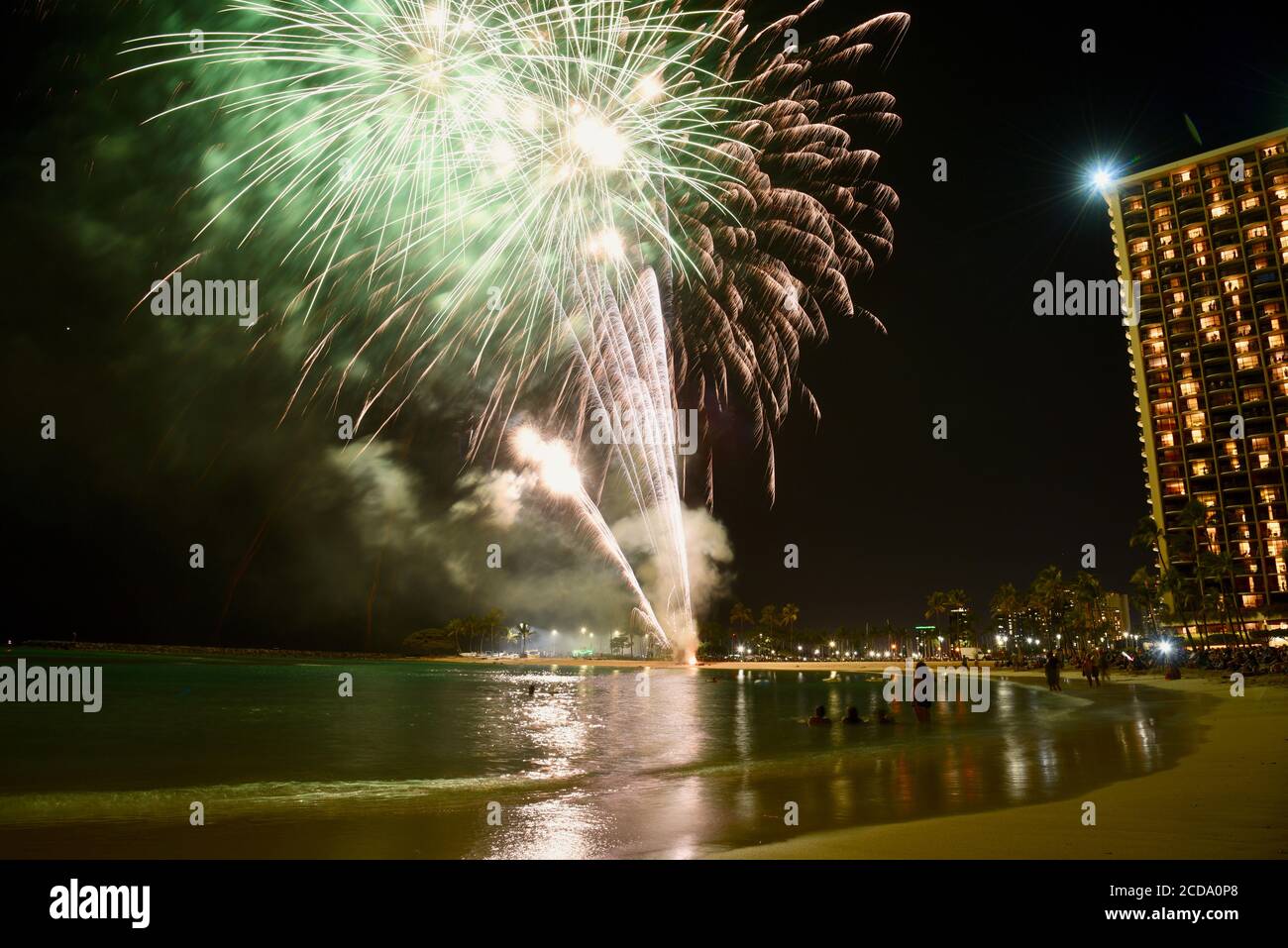 Weekly firework display over touristy beach and waterfront, in front of hotel high rises in the