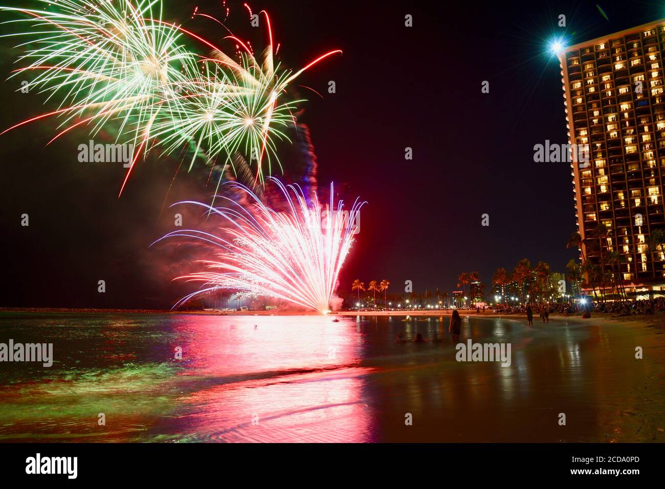 Weekly firework display over touristy beach and waterfront, in front of hotel high rises in the