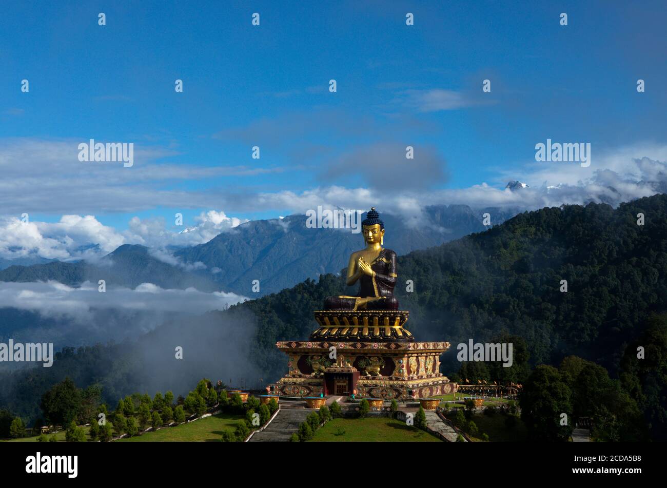 A huge statue of Lord Buddha in a sunny morning in Buddha Park with The Kanchenjunga snow peak in background in Sikkim in India Stock Photo
