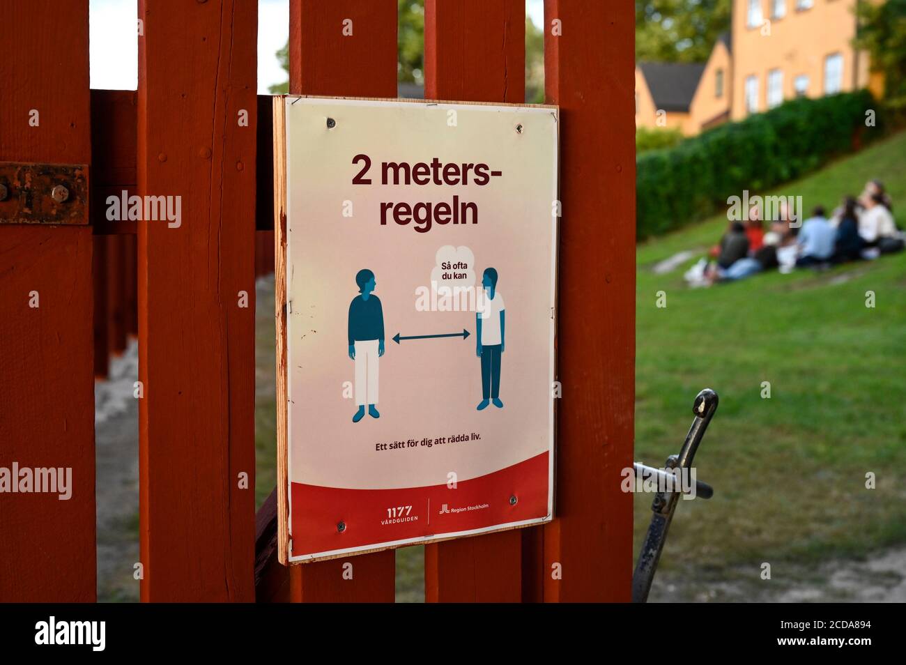SWEDEN, Stockholm, corona pandemic, covid 19 disease, no shutdown and mask requirement, but distance rules, entrance of public park with fence in traditional swedish red paint Stock Photo