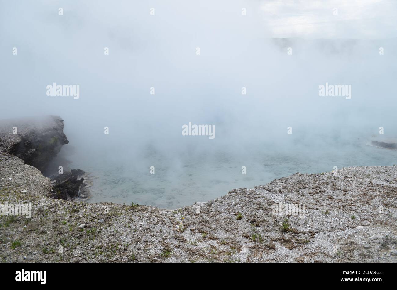 Late Spring in Yellowstone National Park: Dense Steam Rolls Off Excelsior Geyser Crater in Midway Geyser Basin Stock Photo
