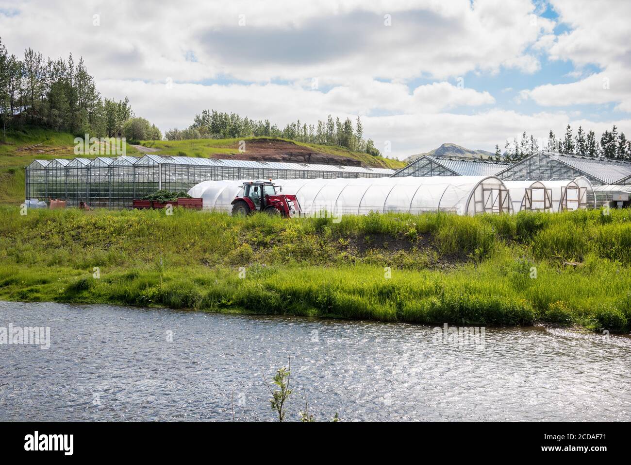 Riverside geothermal heated greenhouses on a cloudy summer day Stock Photo
