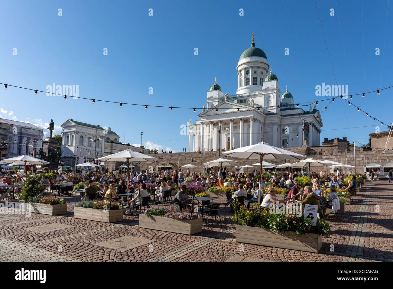 Senate Square turned into giant summer terrace or beer garden serving beverages and  food with Helsinki Cathedral in the background Stock Photo