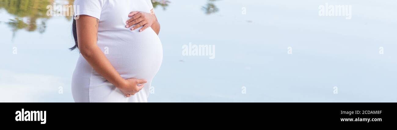 Pregnant asian woman holding her belly Stock Photo - Alamy
