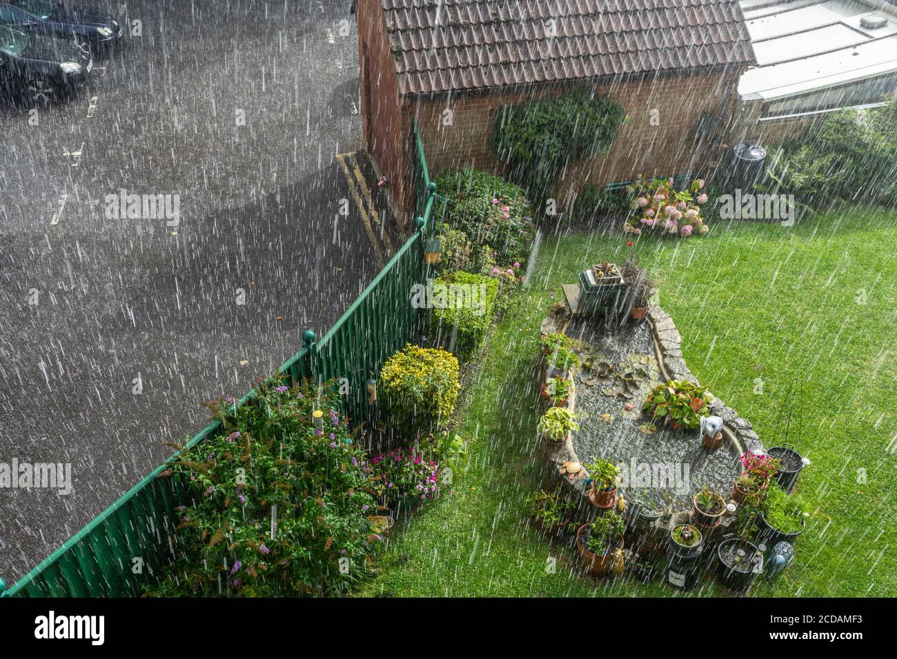 Torrential rainfall / heavy rain during summer over a garden in Southern England, bad weather in the UK Stock Photo