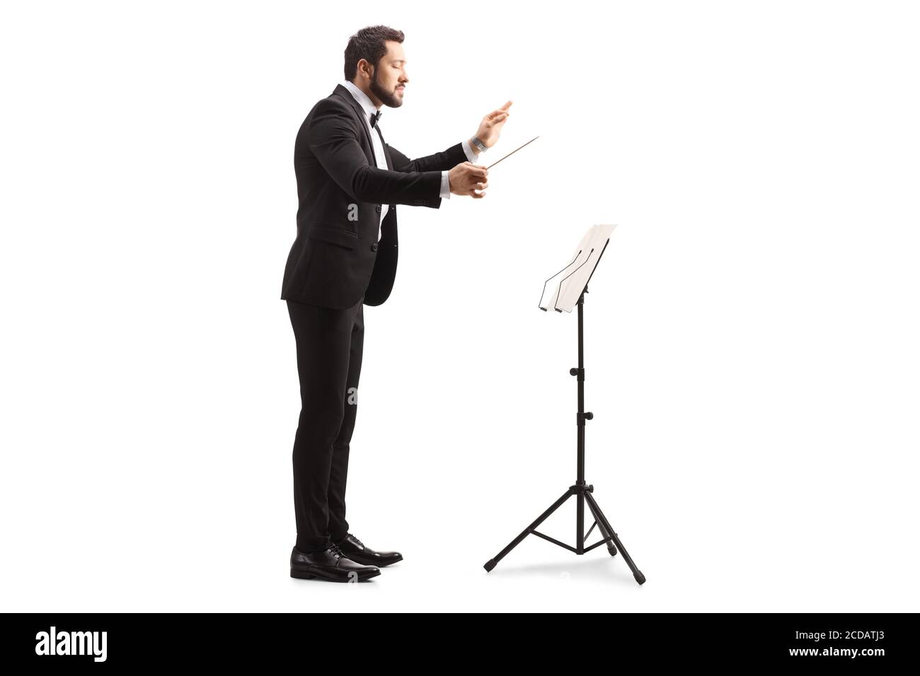 Full length profile shot of a male musical conductor directing with a notebook on a stand isolated on white background Stock Photo