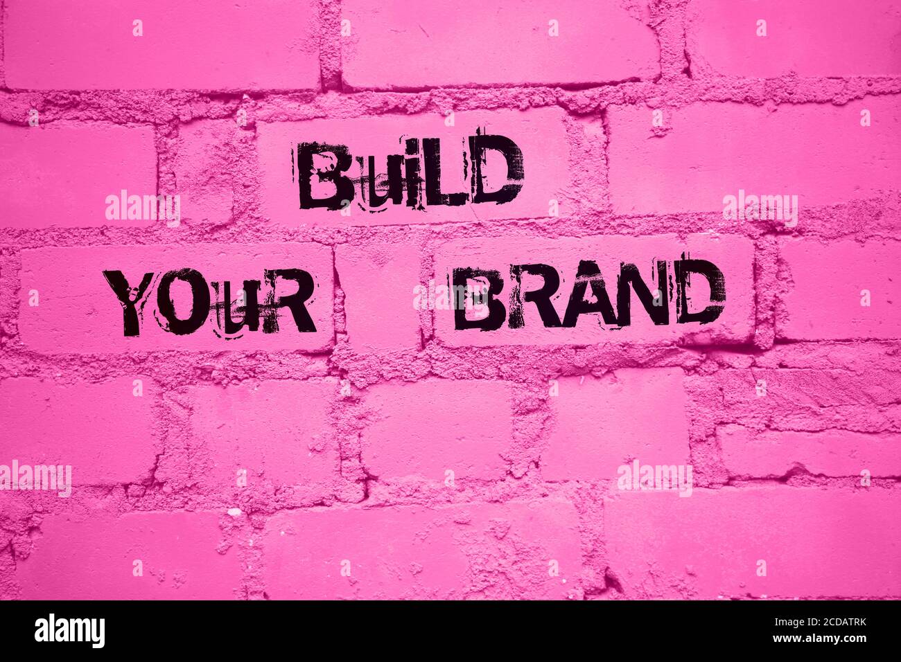 Build Your Brand. words on wall painted into pink. Marketing business concept Stock Photo