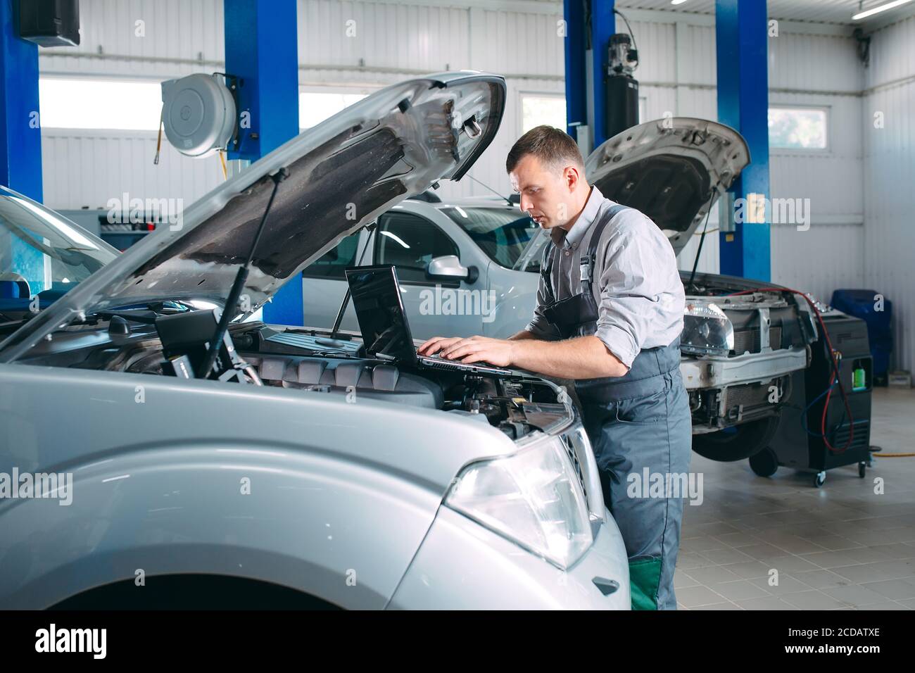 car mechanic using a computer laptop to diagnosing and checking up on