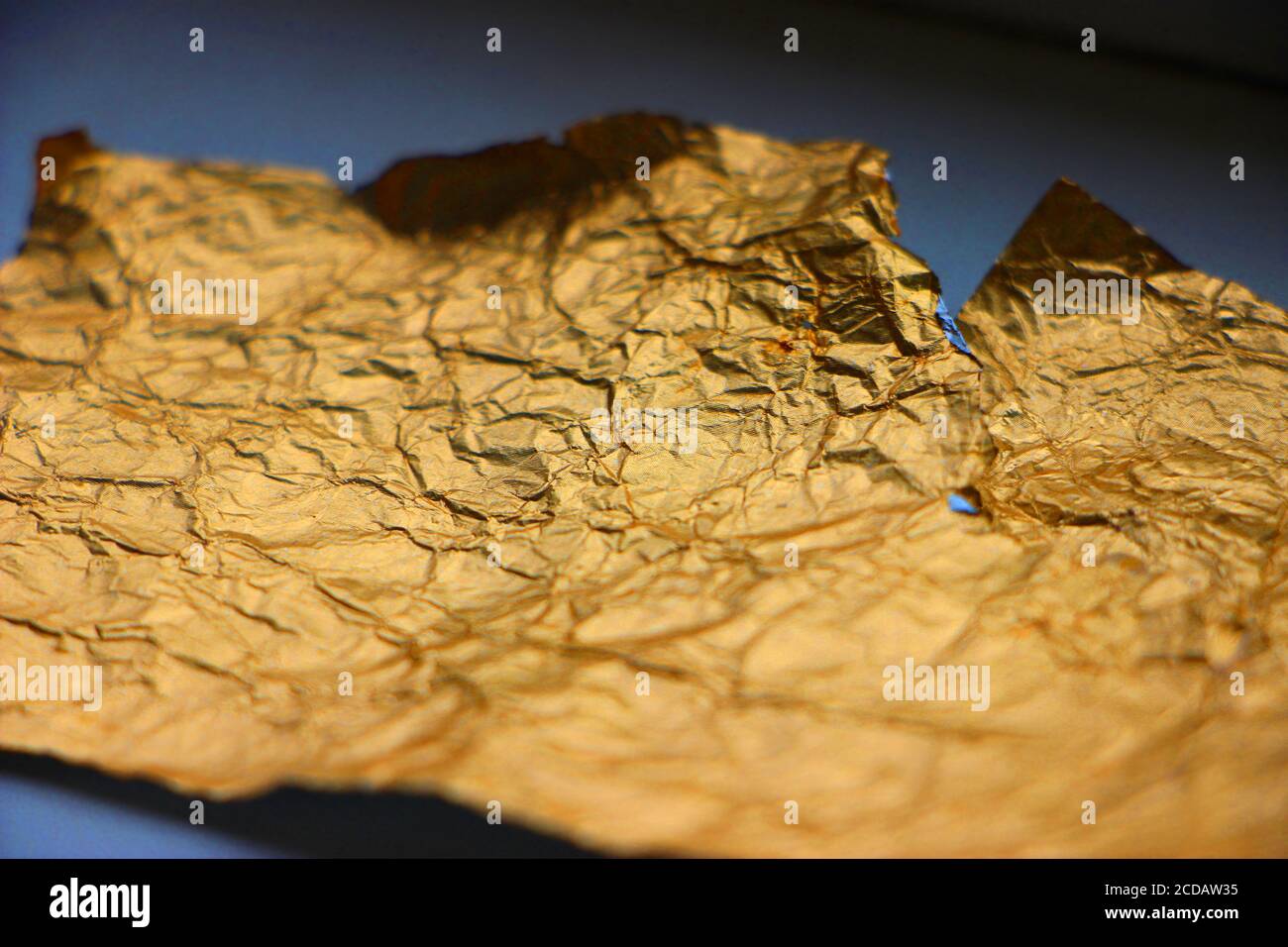 Crumpled torn golden bronze foil texture background Stock Photo