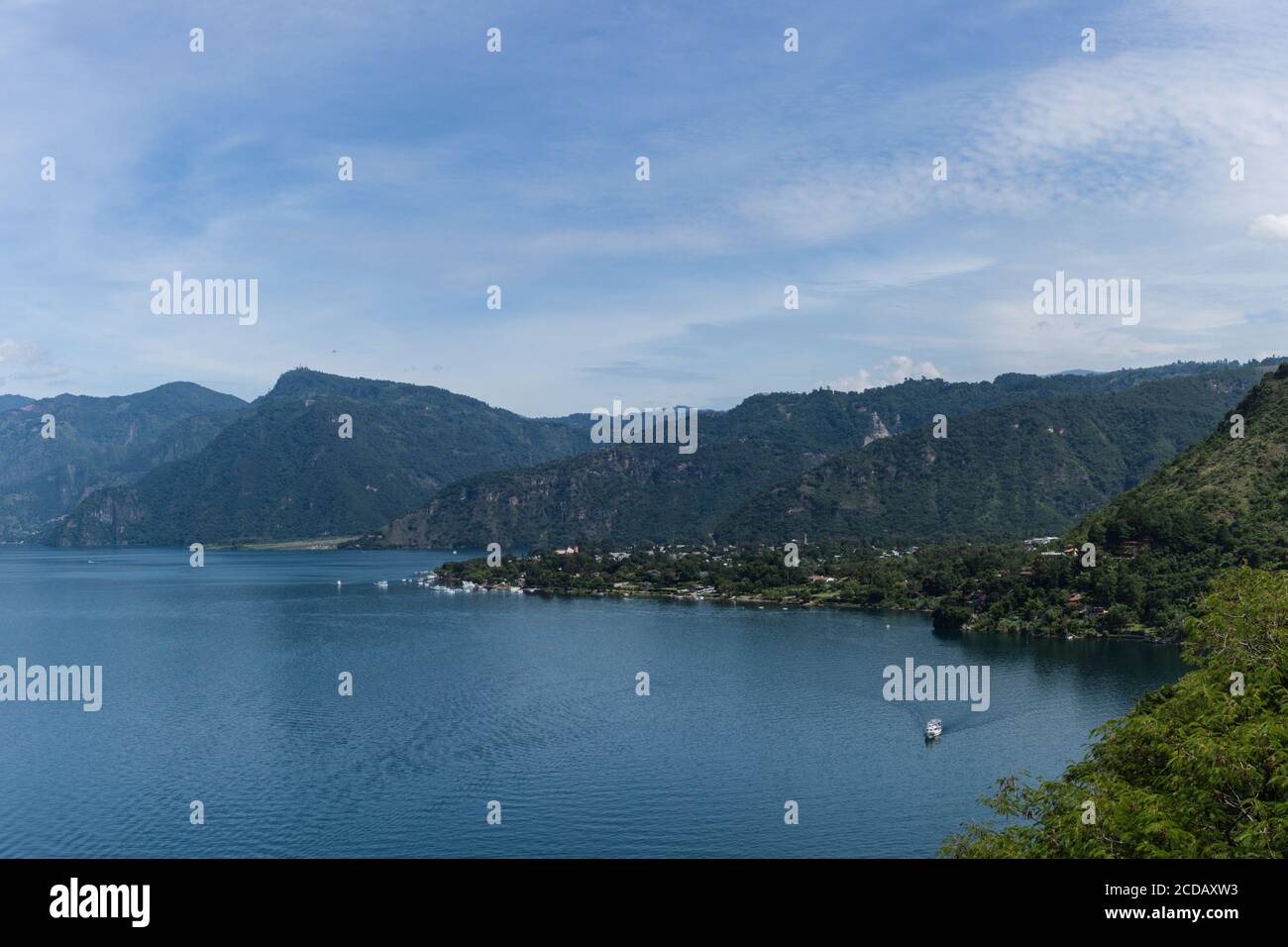 Lake Atitlan with Panajachel, Guatemala.  A tourboat is at lower right.  Lake Atitlan is a caldera or volanic crater filled with water. Stock Photo