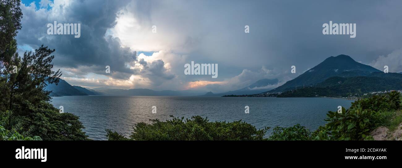 Stormy clouds over Lake Atitlan, Guatemala.  At right is the San Pedro Volcano with San Pedro la Laguna at its base.  San Juan la Laguna is at right. Stock Photo