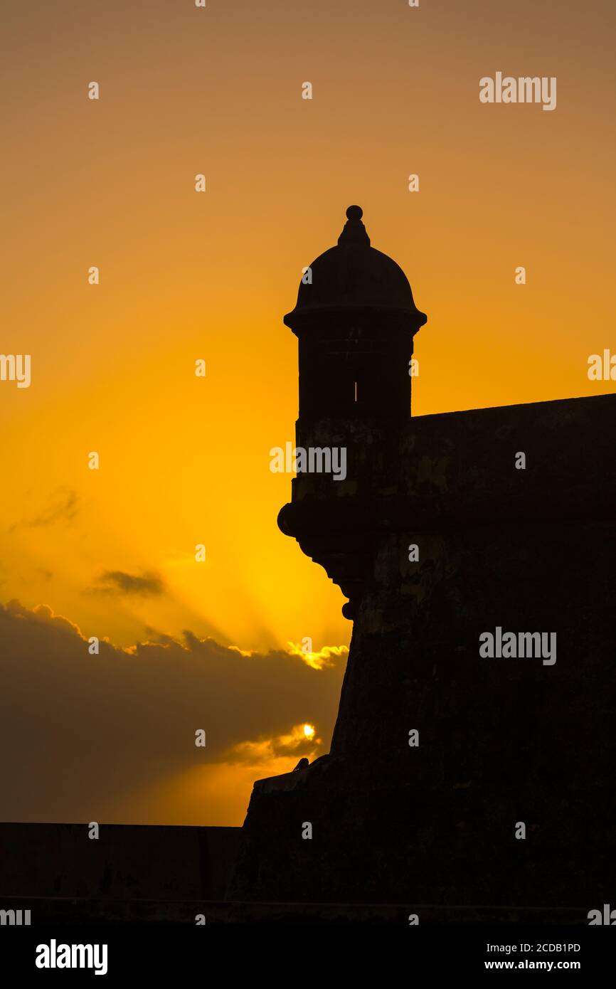 A bartizan, or guerite or sentry box on the wall of Castillo San Felipe del Morro in Old San Juan, Puerto Rico, is sillhouetted against the sunset sky Stock Photo