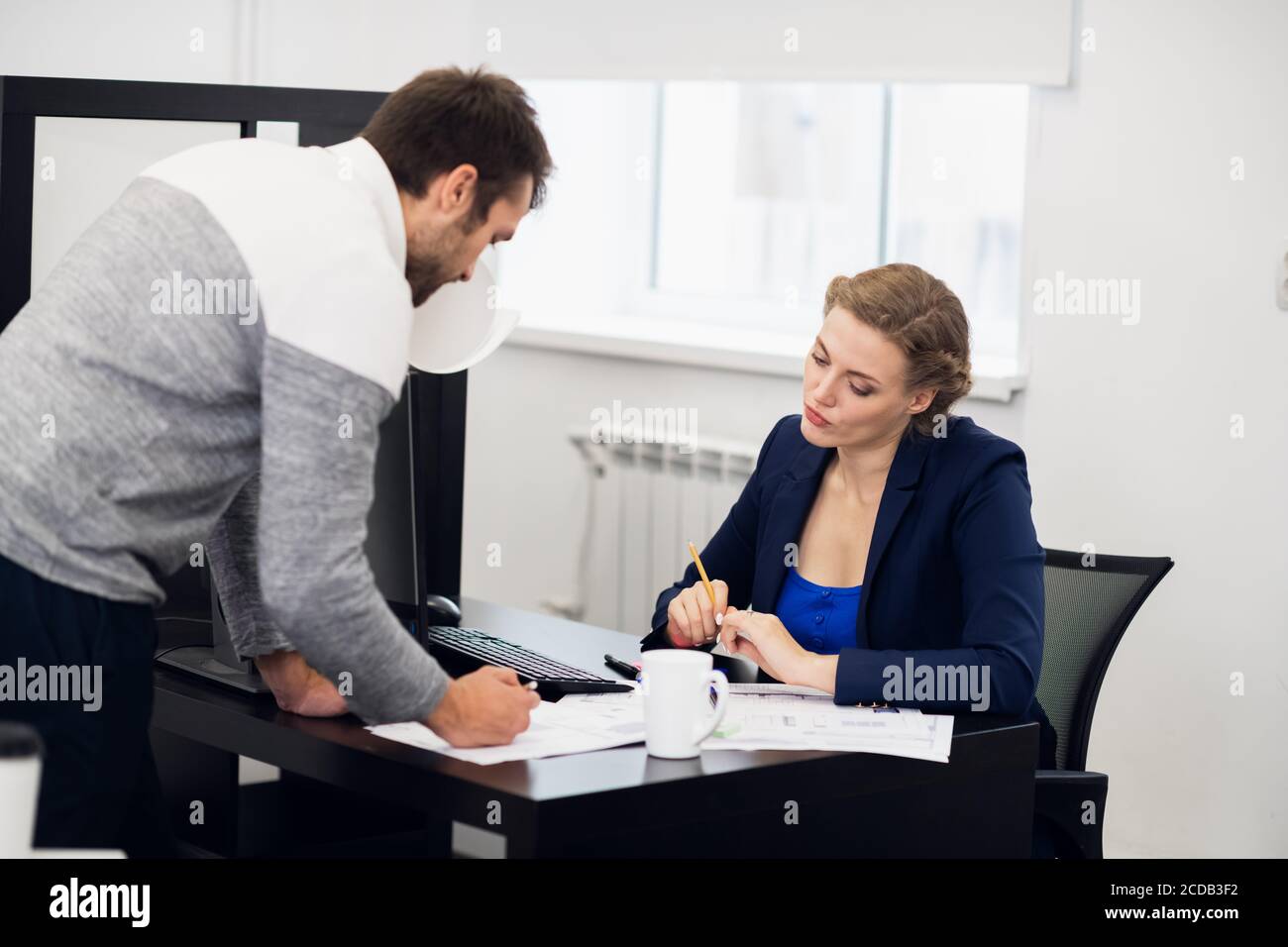 Office routine. Two office workers, a man and a woman, discussing their ...
