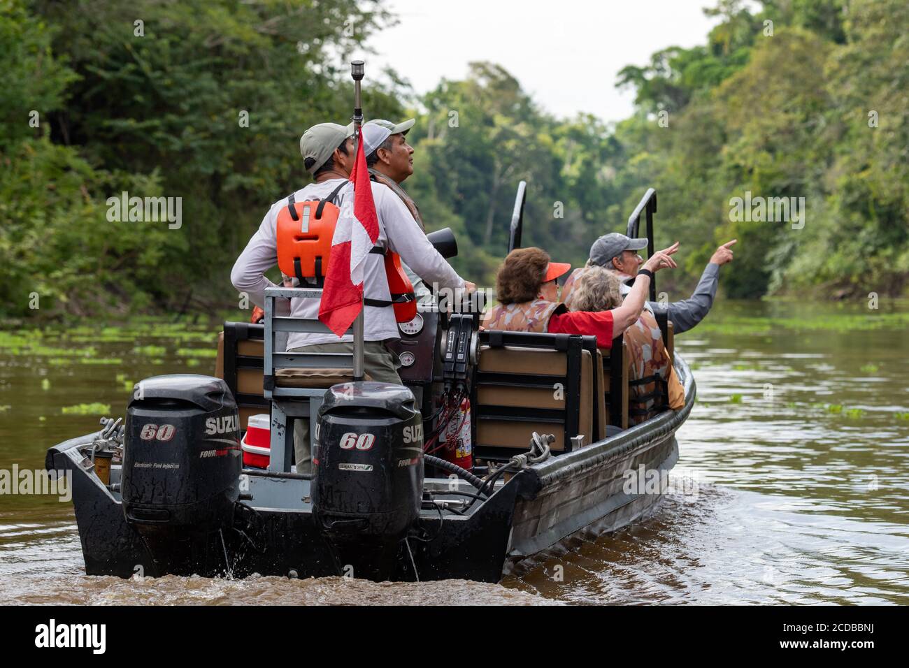 As boat safari from the expeditionary cruise Zafiro looks for wildlife along the Peruvian Amazon Stock Photo