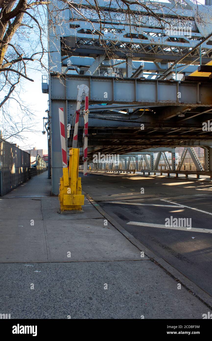street on the Broadway Bridge, a lift bridge, with the traffic gate or barrier upright to allow traffic passing, completely empty of vehicles Stock Photo