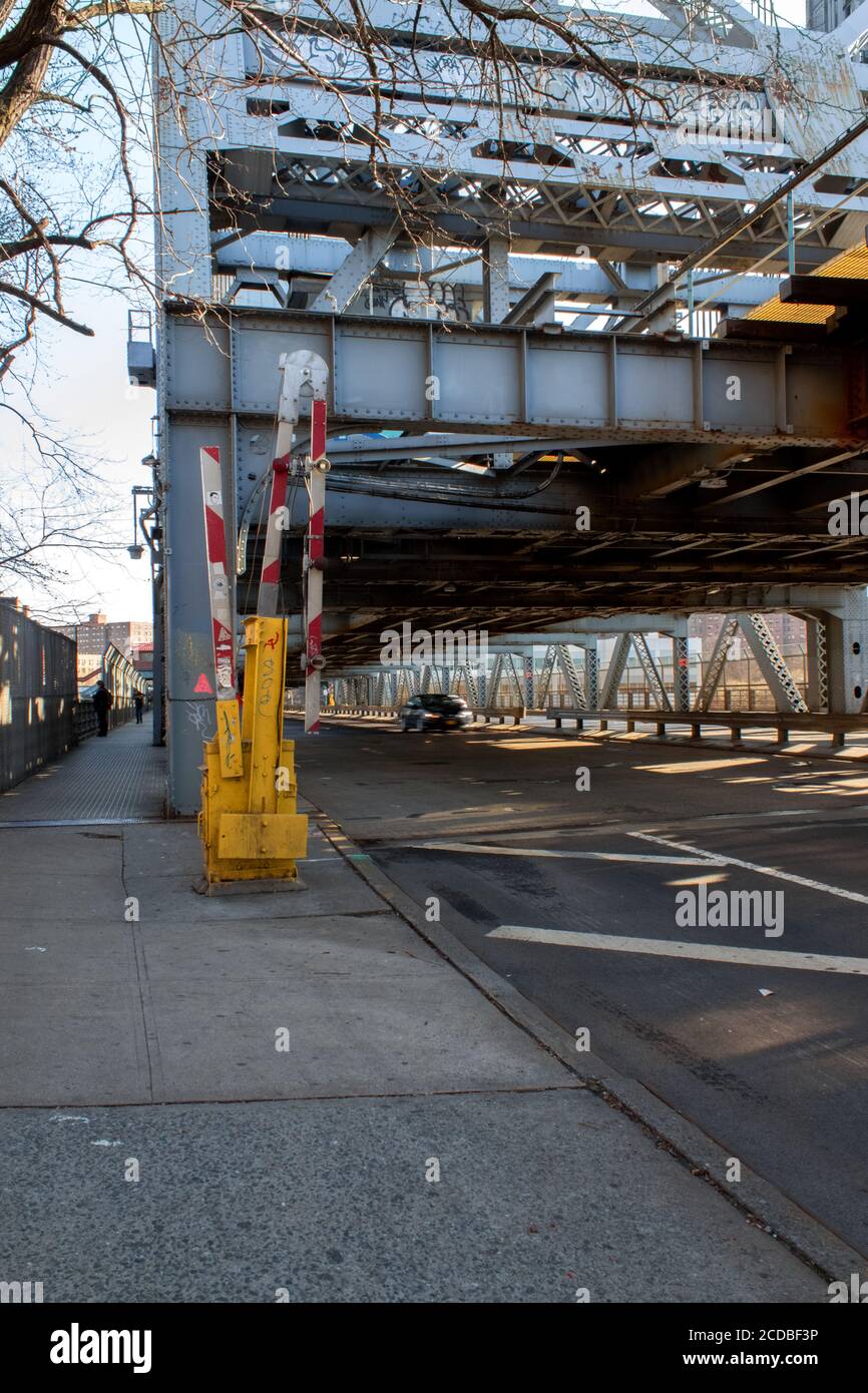 street on the Broadway Bridge, a lift bridge, with the traffic gate or barrier upright to allow traffic passing, a car is seen crossing the bridge Stock Photo