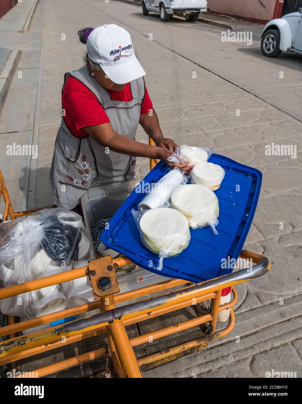 A woman sells queso fresco cheese door to door from her tricycle cart in  San Bartolo Coyotepec, Mexico Stock Photo - Alamy