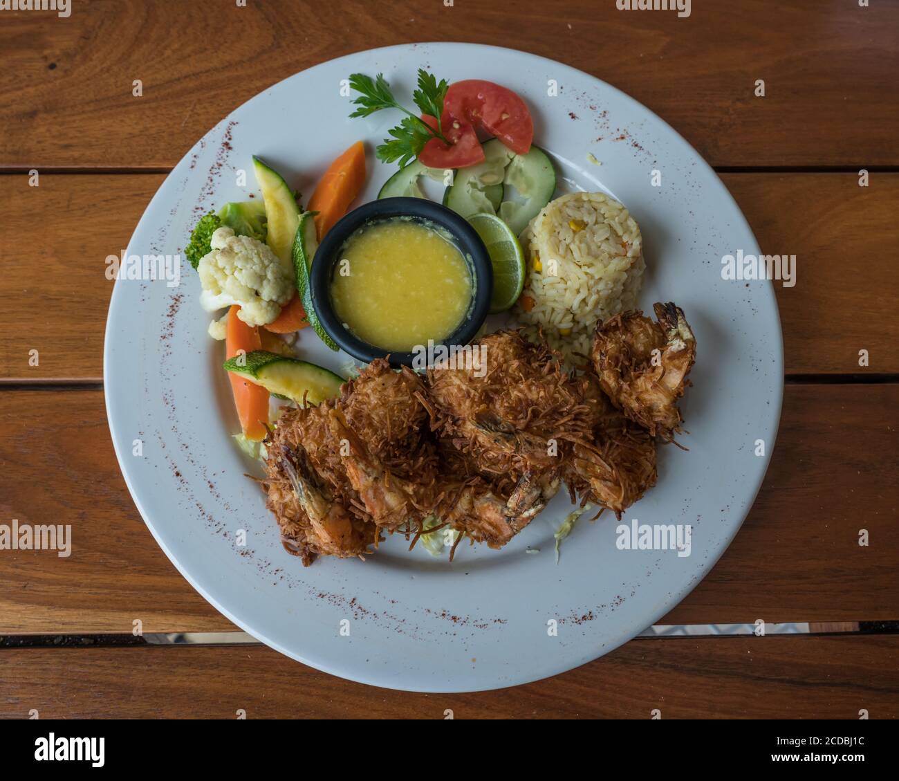 Coconut shrimp with a lime, rice and vegetables by the Caribbean in Mexico. Stock Photo