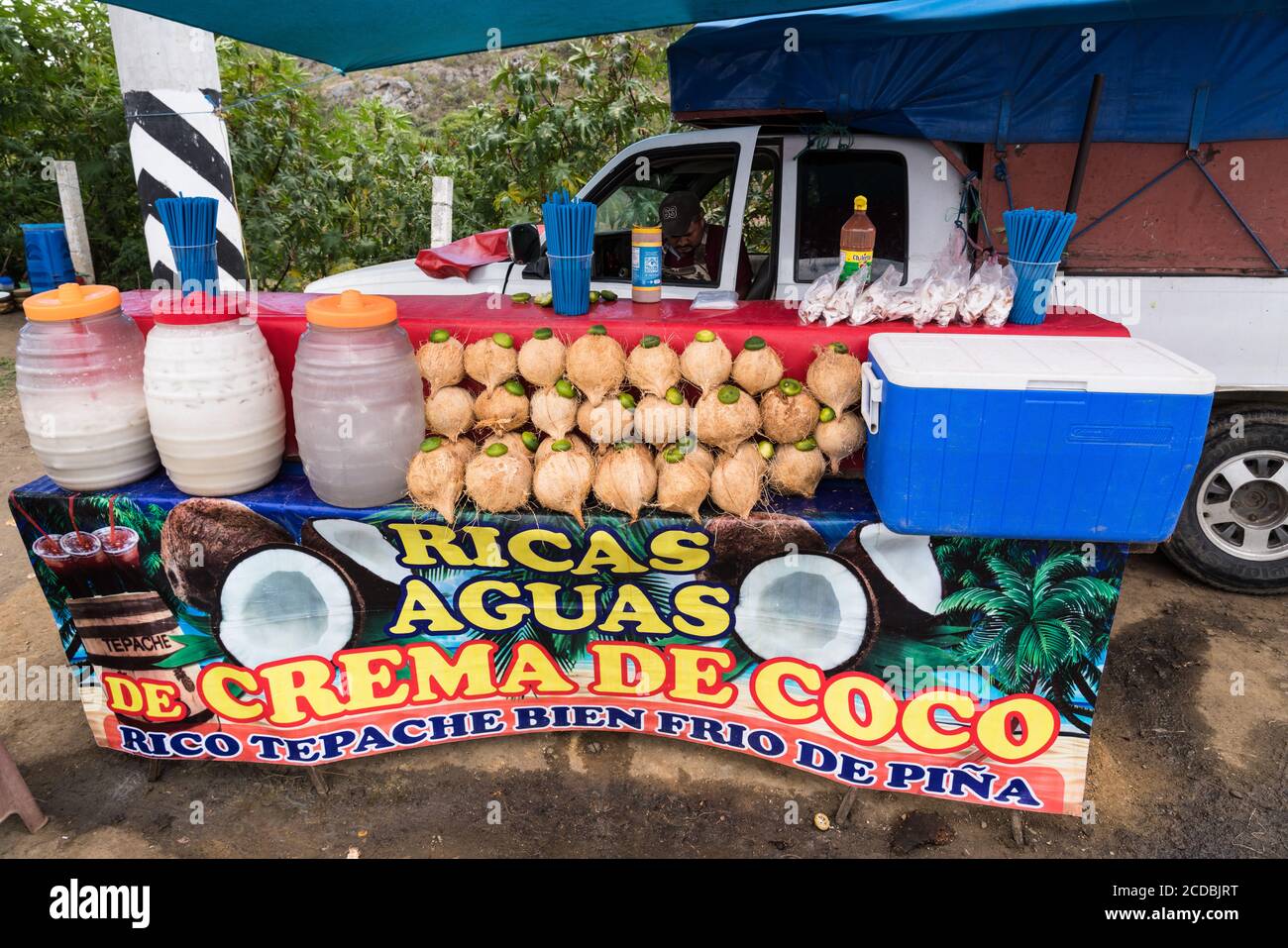 A roadside stand selling fresh coconut meat, coconut milk drinks and fermented tepache on the highway at Mocuilzochil in the valley of Oaxaca, Mexico. Stock Photo