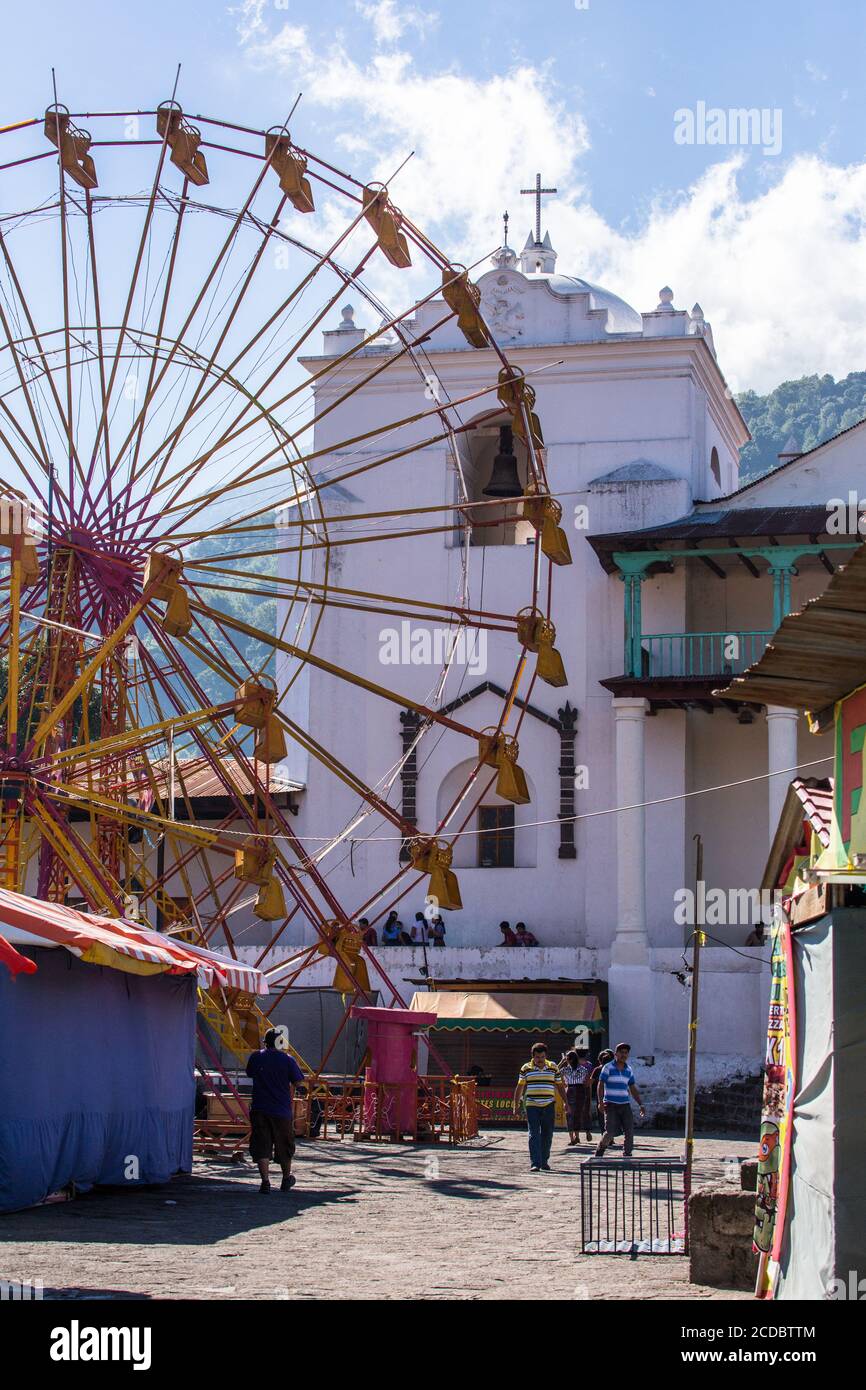 A ferris wheel has been set up in front of the Church of Santiago by the weekly open market in Santiago Atitlan, Guatemala. Stock Photo