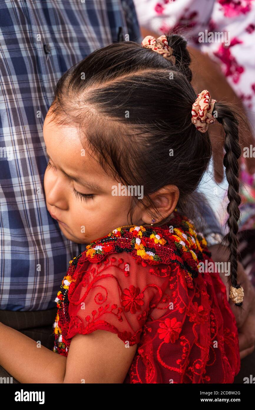 A young Tzutujil Mayan girl in traditional dress hugs her grandfather in Santiago Atitlan, Guatemala. Stock Photo