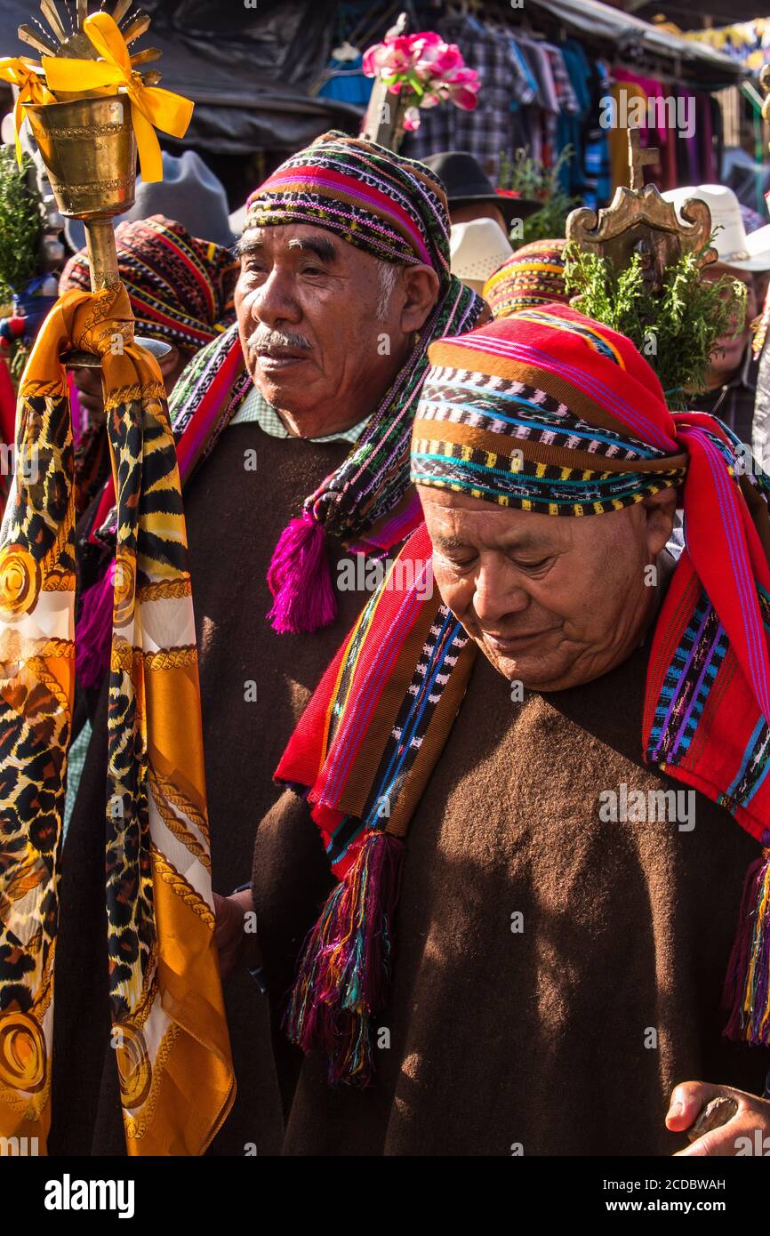 The cofrades or religious officers of the cofradia march in the procession of the FIesta of Santiago in Santiago Atitlan, Guatemala.  They carry their Stock Photo