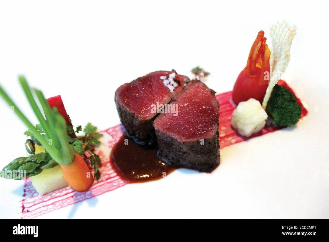 Grilled deer meat with potatoes and spiced foam. White background Stock