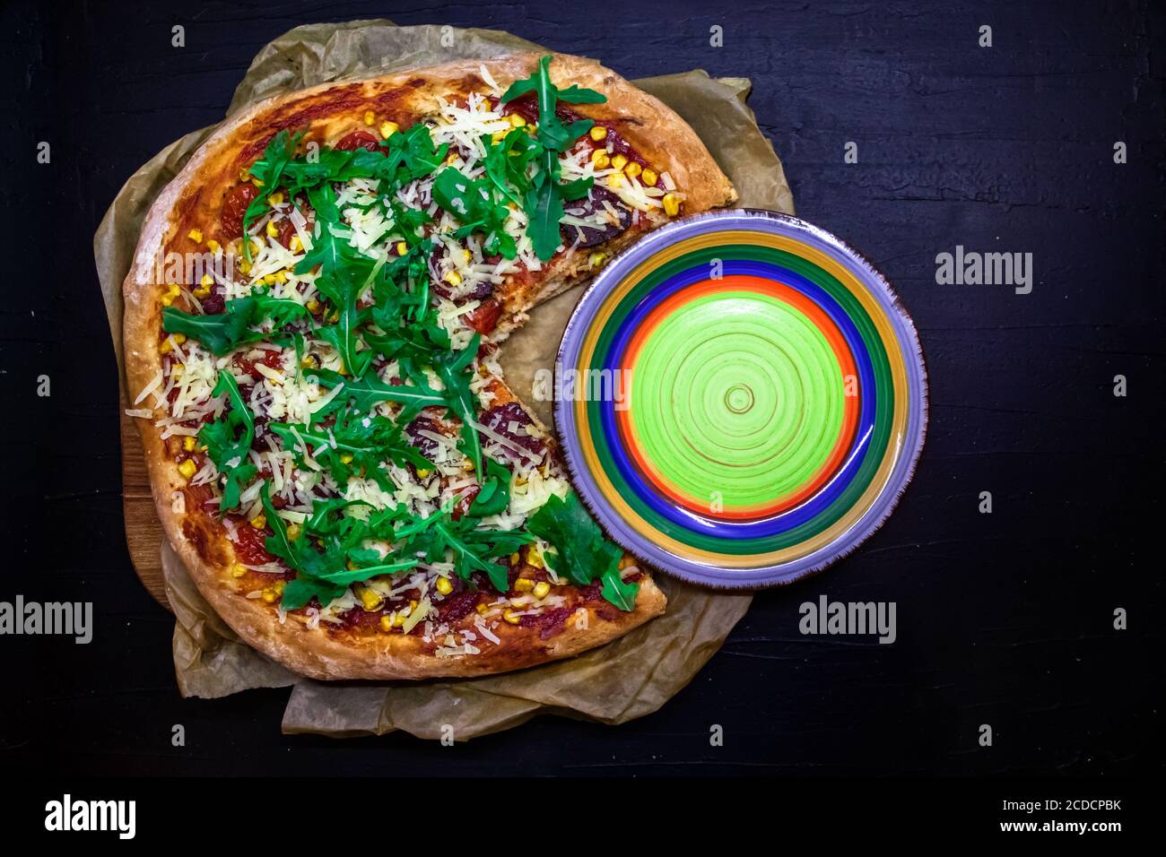 Cooked pizza with a cut part and empty plate between it funny concept. Top view with space for text Stock Photo