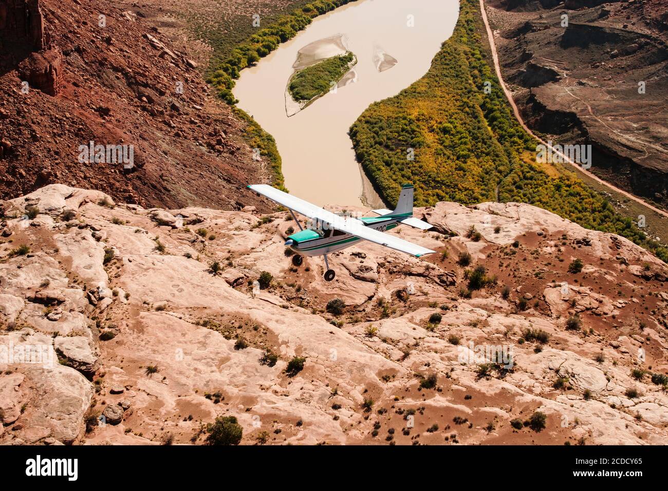 A Cessna 180 Skywagon from the Utah Backcountry Pilots Association flies over the Green River in Labyrinth Canyon near Moab, Utah. Stock Photo