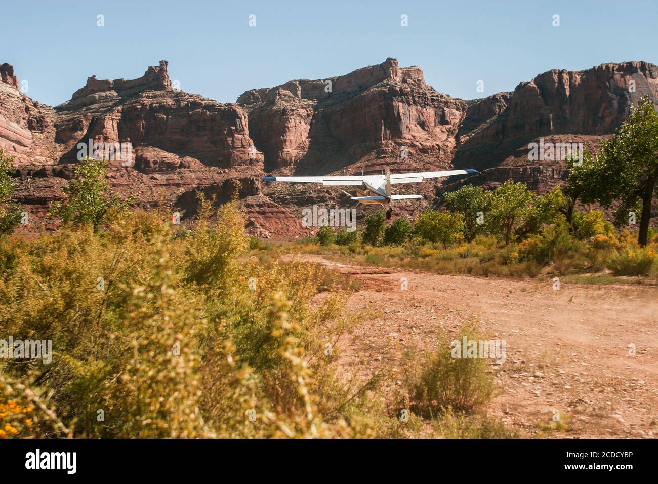 A Cessna 185 Skywagon of the Utah Backcountry Pilots Association takes off from  the remote Mexican Mountain airstrip on the San Rafael Swell in Utah. Stock Photo