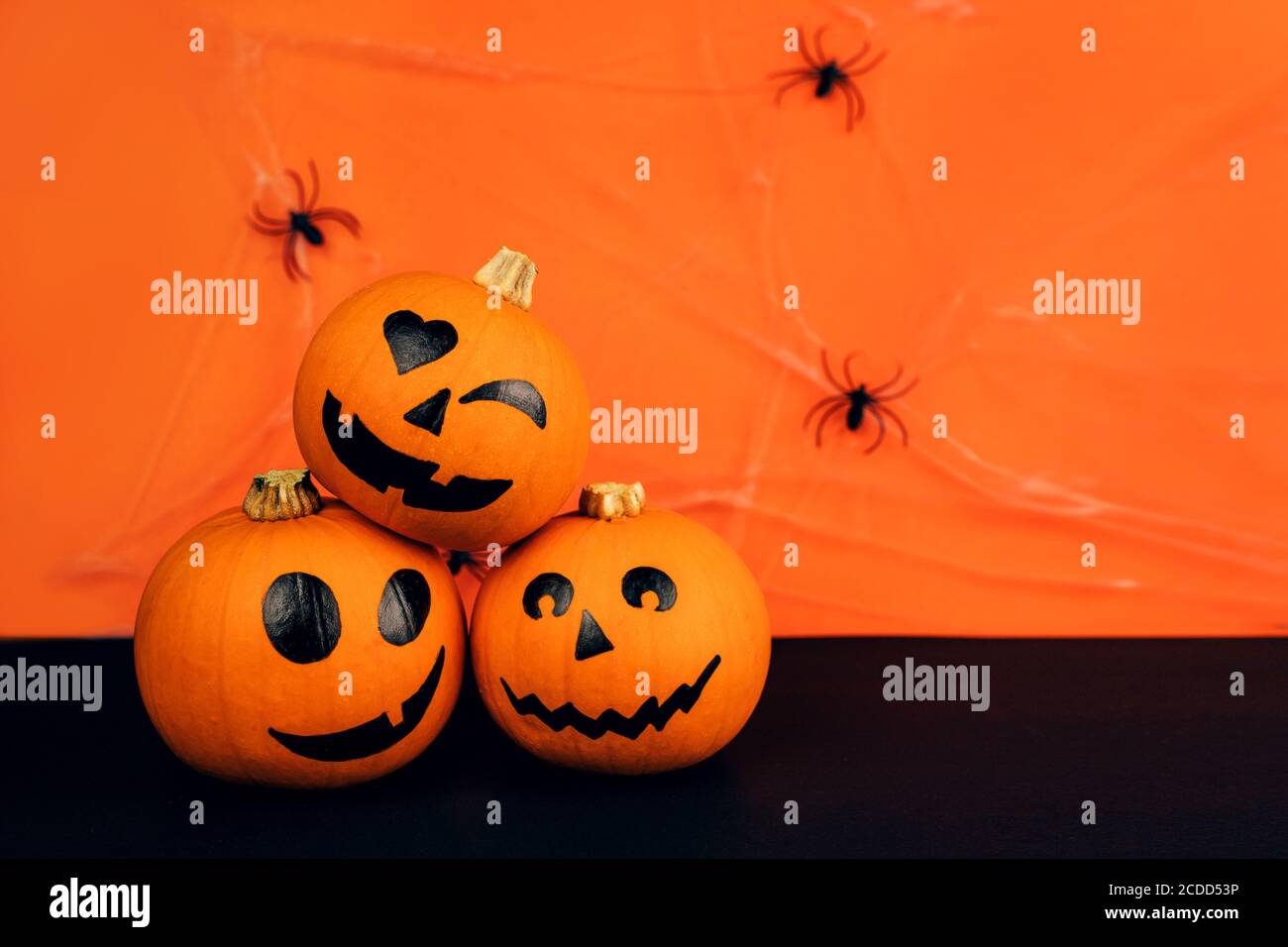 Little Pumpkins With Painted Faces For Halloween With Spiders On The Net On Orange And Black Background Stock Photo Alamy
