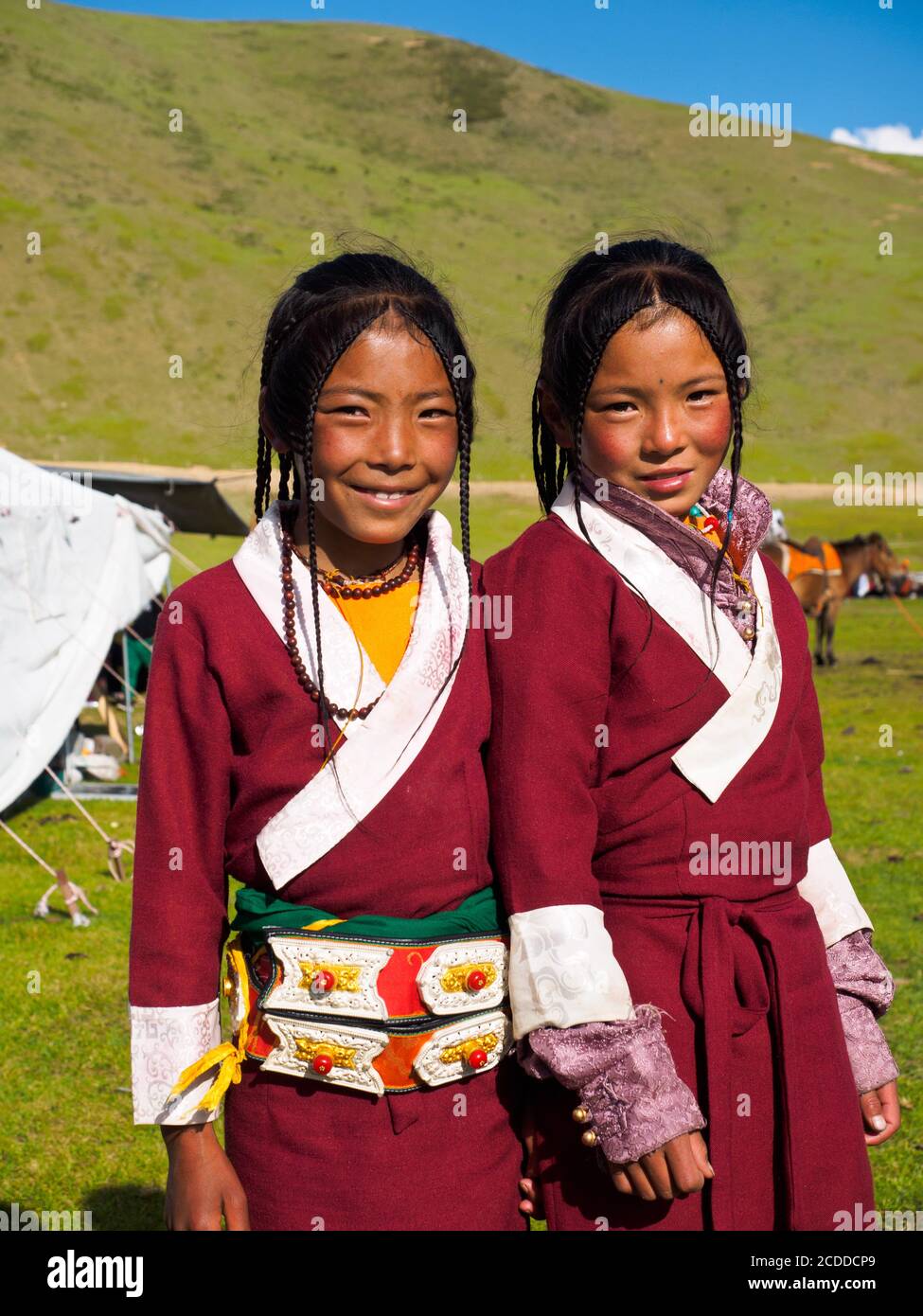 Two nomad Khampa girls dressed up for the festive time, the horse festival near Litang city. Stock Photo