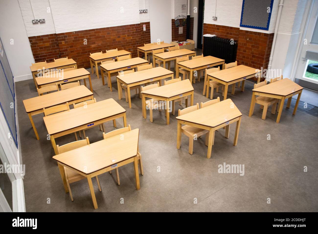 Tables and chairs spaced for social distancing in a classroom as The Charles Dickens Primary School in London prepares to safely welcome back pupils. Stock Photo