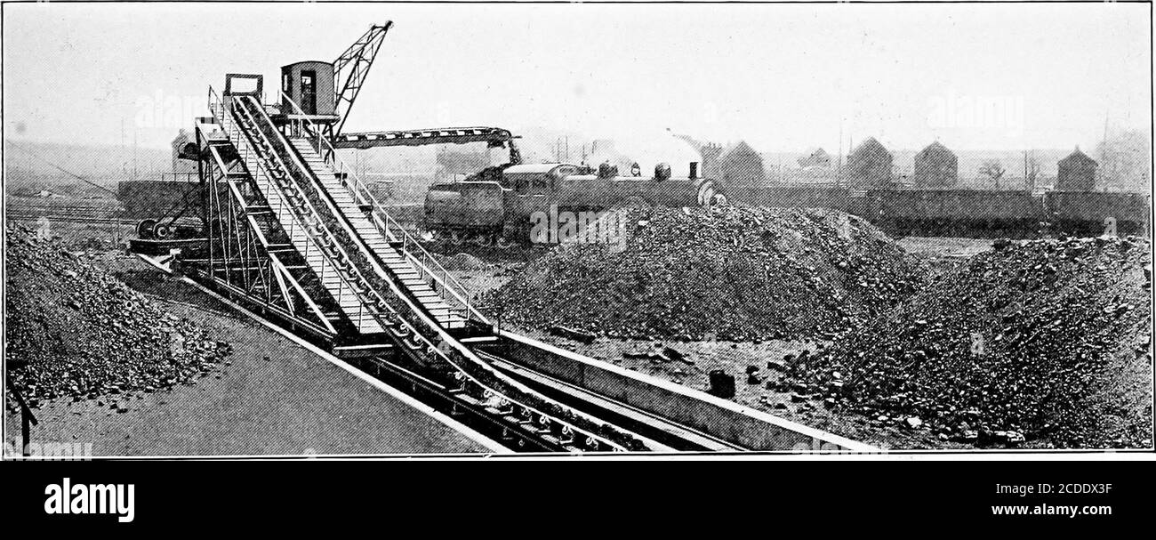 . Material handling cyclopedia; a reference book covering definitions, descriptions, illustrations and methods of use of material handling machines employed in industry . Fig. 17—A Pivoted Bridge Carries the Reclaiming Conveyor. Fig. 18—The Stacker May Be Used for Storing or Coaling Locomotives capable of handling the coal back to the belt conveyor atabout the same rate. Some coal storage plants somewhat similar to the Stuartsystem use a belt conveyor stacker only for making an tracks and the belt conveyor, and also covers a large spaceoutside the tracks. In this way a very large area can beco Stock Photo